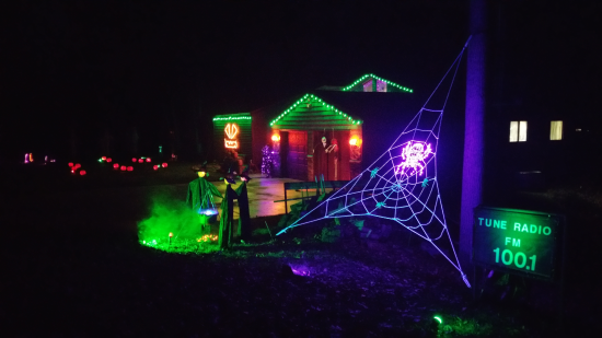Nighttime pic of yard and house lit up during Halloween